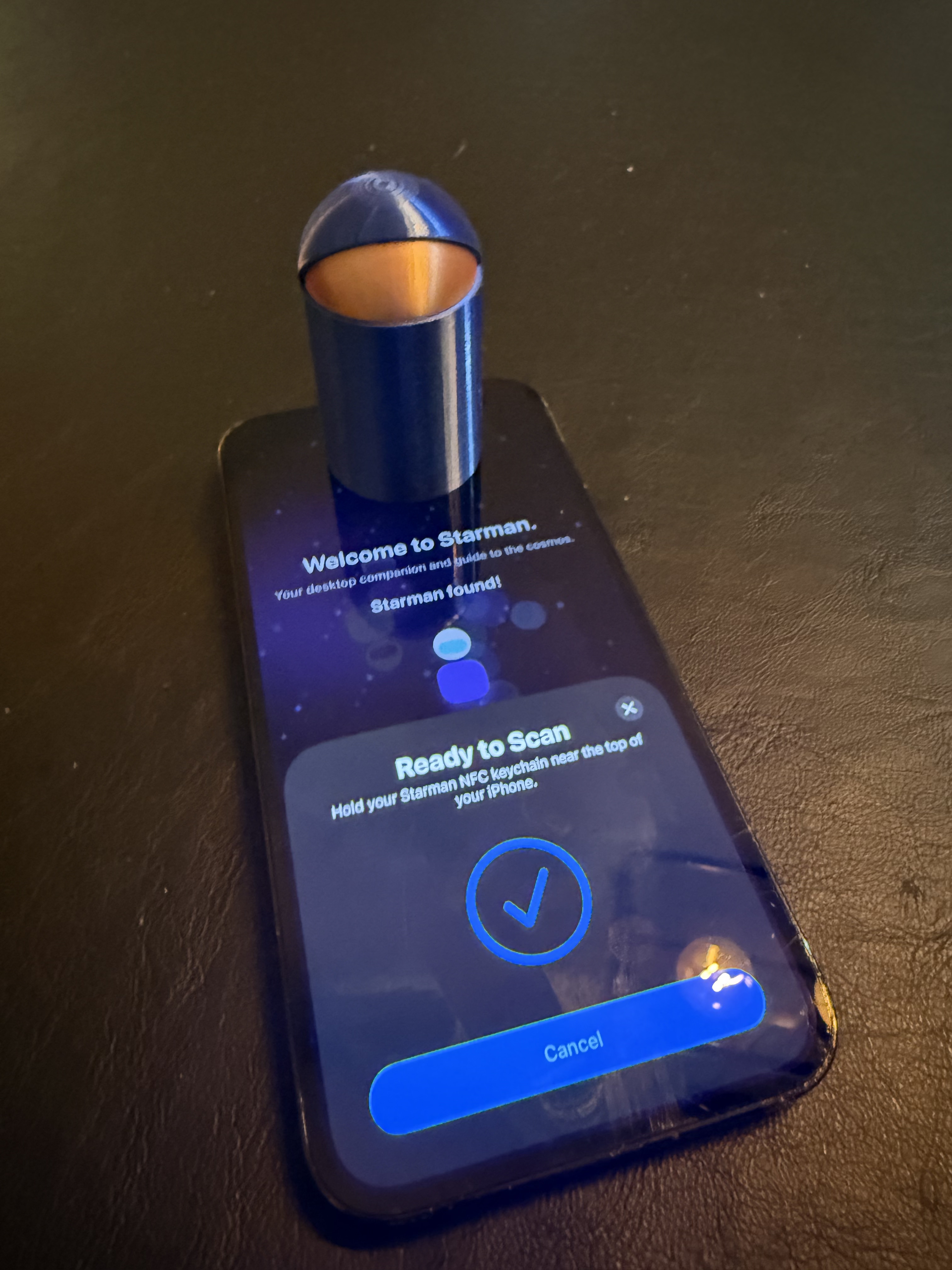 Blue Starbuddy tapping an iPhone to pair Starman