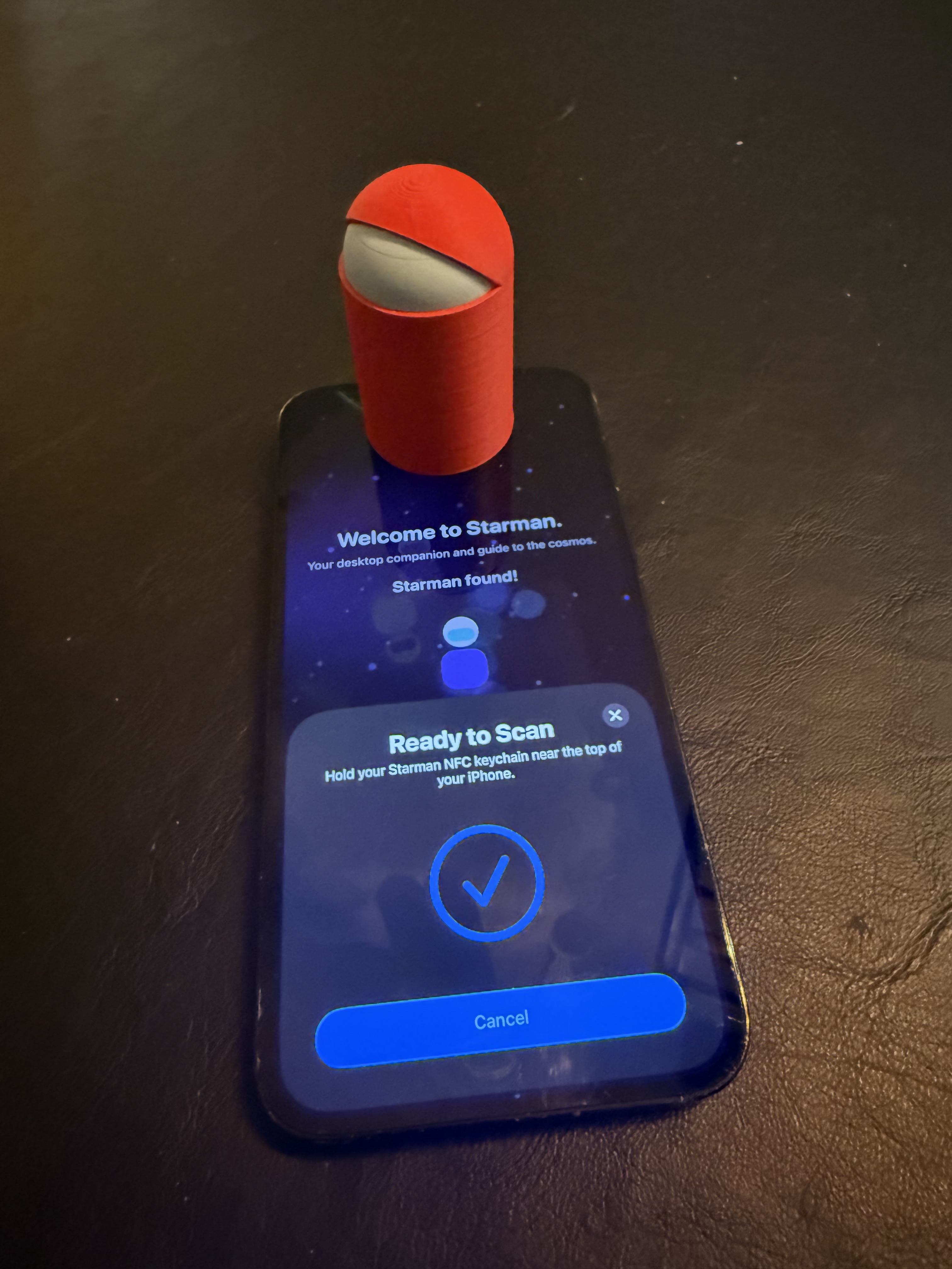 Red Starbuddy tapping an iPhone to pair Starman